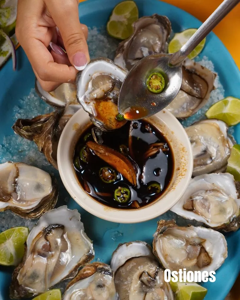 Post de El Buca: ostiones servidos sobre plato azul con salsa y limón