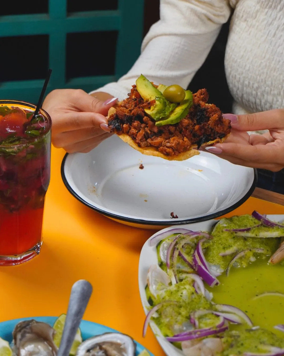 Comensales compartiendo tostadas y bebidas en El Buca